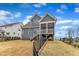 View of a charming gray two-story home with a screened porch and a well-maintained, fenced backyard at 112 Sire Ct, Holly Springs, NC 27540