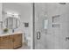 Modern bathroom featuring a vanity, round mirror, tile floors and a glass-door shower at 112 Sire Ct, Holly Springs, NC 27540