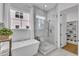 Bright white bathroom featuring a soaking tub, glass shower, and closet at 112 Sire Ct, Holly Springs, NC 27540