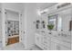 Bright bathroom featuring a double vanity, a large mirror, and a view to the closet at 112 Sire Ct, Holly Springs, NC 27540