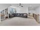 Bonus room featuring a ceiling fan, built-in shelving, and a large leather sectional sofa at 112 Sire Ct, Holly Springs, NC 27540