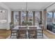 Bright dining room featuring a rustic wood table, modern chandelier, and large windows with views at 112 Sire Ct, Holly Springs, NC 27540
