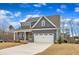 Charming home boasts a two-car garage, covered porch, and manicured lawn, perfect for suburban living at 112 Sire Ct, Holly Springs, NC 27540