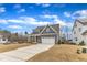 Charming home boasts a two-car garage, covered porch, and manicured lawn, perfect for suburban living at 112 Sire Ct, Holly Springs, NC 27540