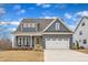 Charming two-story home with a two-car garage, a quaint front porch, and manicured landscaping at 112 Sire Ct, Holly Springs, NC 27540