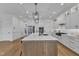 Modern kitchen featuring a large island, white cabinets, and stainless steel appliances at 112 Sire Ct, Holly Springs, NC 27540