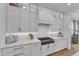 Gourmet kitchen featuring custom white cabinets, gas range, and quartz countertops at 112 Sire Ct, Holly Springs, NC 27540