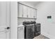Laundry room featuring a modern washer and dryer, tile floors and overhead cabinets at 112 Sire Ct, Holly Springs, NC 27540