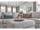 Comfortable white sectional sofa with decorative pillows and a styled ottoman in a bright living area at 112 Sire Ct, Holly Springs, NC 27540