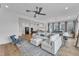 Open-concept living room with a modern white sectional, hardwood floors, and seamless flow to dining area at 112 Sire Ct, Holly Springs, NC 27540