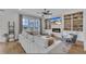Sunlit living room with a modern fireplace, custom built-ins, and a comfortable white sectional sofa at 112 Sire Ct, Holly Springs, NC 27540