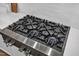 Close up of stainless steel six-burner gas range in a kitchen with white backsplash at 112 Sire Ct, Holly Springs, NC 27540