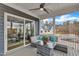 Relaxing screened porch with comfortable seating, glass table, ceiling fan and views of the surrounding neighborhood at 112 Sire Ct, Holly Springs, NC 27540