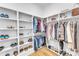 Bright walk-in closet featuring custom shelving, hanging rods and hardwood floors at 112 Sire Ct, Holly Springs, NC 27540