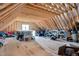 Unfinished attic space with exposed wood beams, subfloor, and one window at 1124 Westridge Rd, Rougemont, NC 27572