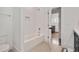 Bathroom with tub/shower combo and all white tile, along with built-in soap holder and access to the laundry room at 1124 Westridge Rd, Rougemont, NC 27572