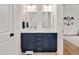 Bright bathroom featuring a double sink vanity with navy blue cabinets, and decorative mirrors at 1124 Westridge Rd, Rougemont, NC 27572