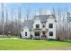 Inviting two-story white farmhouse with a covered front porch, rocking chairs, and lush green lawn at 1124 Westridge Rd, Rougemont, NC 27572
