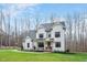 Inviting two-story white farmhouse with a covered front porch, rocking chairs, and lush green lawn at 1124 Westridge Rd, Rougemont, NC 27572