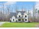 Charming two-story white farmhouse with a covered front porch, rocking chairs, and a well-maintained lawn at 1124 Westridge Rd, Rougemont, NC 27572