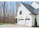White farmhouse-style home with a two-car garage, screened porch, and manicured landscaping at 1124 Westridge Rd, Rougemont, NC 27572