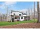 Rear view of a two-story white home showcasing a covered porch and a screened in porch at 1124 Westridge Rd, Rougemont, NC 27572