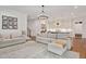 Open-concept living room with eat-in kitchen, modern lighting, and white furnishings at 1124 Westridge Rd, Rougemont, NC 27572