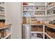 Walk-in pantry features built-in shelving with baskets and wood countertop with beverage cooler at 1124 Westridge Rd, Rougemont, NC 27572