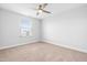 A bright, carpeted bedroom featuring a ceiling fan and a window with blinds at 1201 Canary Pepper Dr, Durham, NC 27713