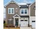 Charming two-story townhome with a well-manicured lawn, a blue front door and an attached garage at 1201 Canary Pepper Dr, Durham, NC 27713