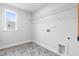 A clean laundry room offers a window, gray tile floors, and a wire rack for organized storage at 1201 Canary Pepper Dr, Durham, NC 27713