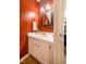 Charming half-bathroom with a white vanity, sink, framed mirror, and warm red wall color at 121 Westview Dr # 106, Carrboro, NC 27510
