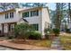 Charming townhome featuring a well maintained lawn, mature trees, brick walkway, and lush green shrubbery at 121 Westview Dr # 106, Carrboro, NC 27510