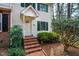 Charming two-story townhome with landscaped yard, brick walkway and white door with green shutters at 121 Westview Dr # 106, Carrboro, NC 27510