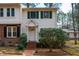 Charming townhome featuring a well maintained lawn, mature trees, brick walkway, and white door with green shutters at 121 Westview Dr # 106, Carrboro, NC 27510