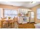 Bright kitchen with white appliances and adjacent dining area with hardwood floors at 121 Westview Dr # 106, Carrboro, NC 27510