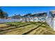 Large backyard with a pergola and white fence provides ample space for recreation and relaxation at 124 Kipling Dr, Oxford, NC 27565