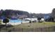Community pool area with a pool house, umbrellas, and landscaped green space at 124 Kipling Dr, Oxford, NC 27565
