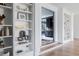 Hallway with hardwood floors, white trim, and built-in shelving featuring decorative items at 1421 Sky Vista Way, Raleigh, NC 27613