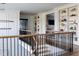 Bright hallway featuring hardwood floors, black metal railings, and built in bookshelves at 1421 Sky Vista Way, Raleigh, NC 27613