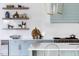 Modern kitchen boasts custom cabinetry, open shelving, and a professional-grade range, blending style and functionality at 1421 Sky Vista Way, Raleigh, NC 27613