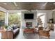 Cozy outdoor living space with a fireplace, TV, comfortable seating, and a serene backyard view at 1421 Sky Vista Way, Raleigh, NC 27613