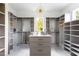 Spacious walk-in closet with custom shelving, island with drawers, and decorative chandelier at 1421 Sky Vista Way, Raleigh, NC 27613