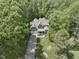 Green home nestled in a mature treeline, featuring a two-car garage, large lawn, and welcoming front porch at 1425 Princess Anne Rd, Cary, NC 27607