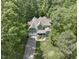 Green home featuring a mature treeline, two-car garage, large lawn, and welcoming front porch at 1425 Princess Anne Rd, Cary, NC 27607