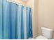 Bathroom with blue striped shower curtain and standard toilet at 1425 Princess Anne Rd, Cary, NC 27607