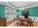 Bright dining room with large windows, a wooden table, and teal walls offering a pleasant dining experience at 1425 Princess Anne Rd, Cary, NC 27607