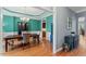 Elegant dining room featuring vibrant teal walls, a classic chandelier, and hardwood flooring at 1425 Princess Anne Rd, Cary, NC 27607