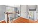 Hallway with wood floors and staircase featuring decorative railing and natural light at 1425 Princess Anne Rd, Cary, NC 27607