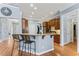 Well-lit kitchen with wooden cabinets, hardwood flooring, and breakfast bar with seating for two at 1425 Princess Anne Rd, Cary, NC 27607